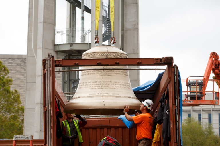 A bell emerges from a shipping container