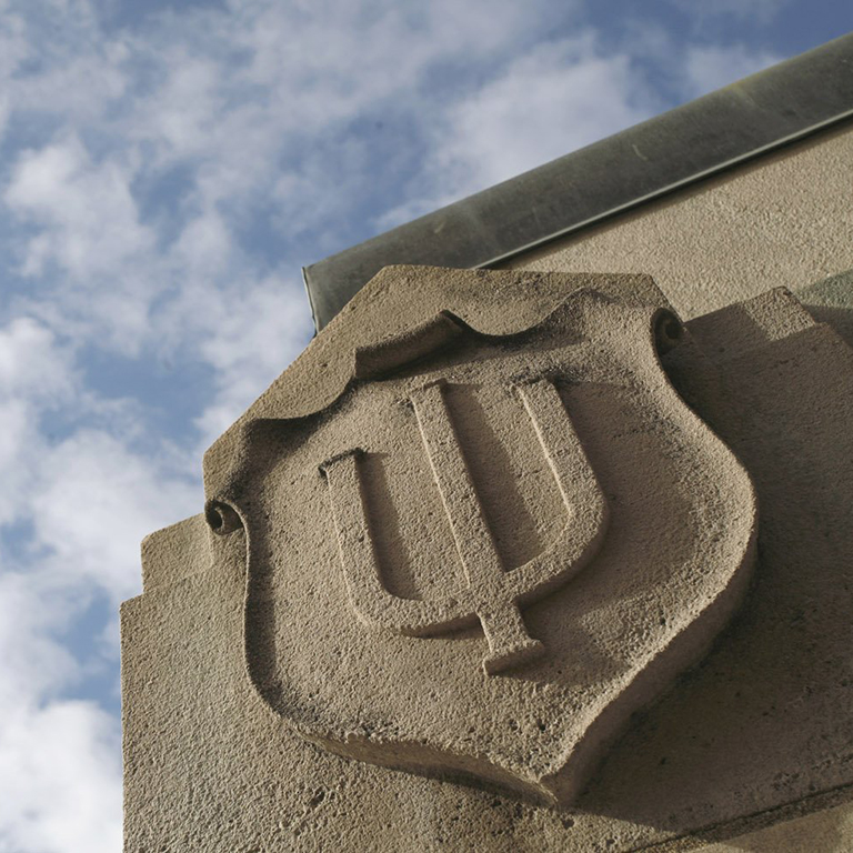 A photo of a limestone IU trident on a building.